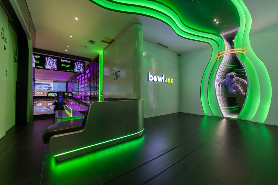 The Bowl.inc sign lit green beside the lanes