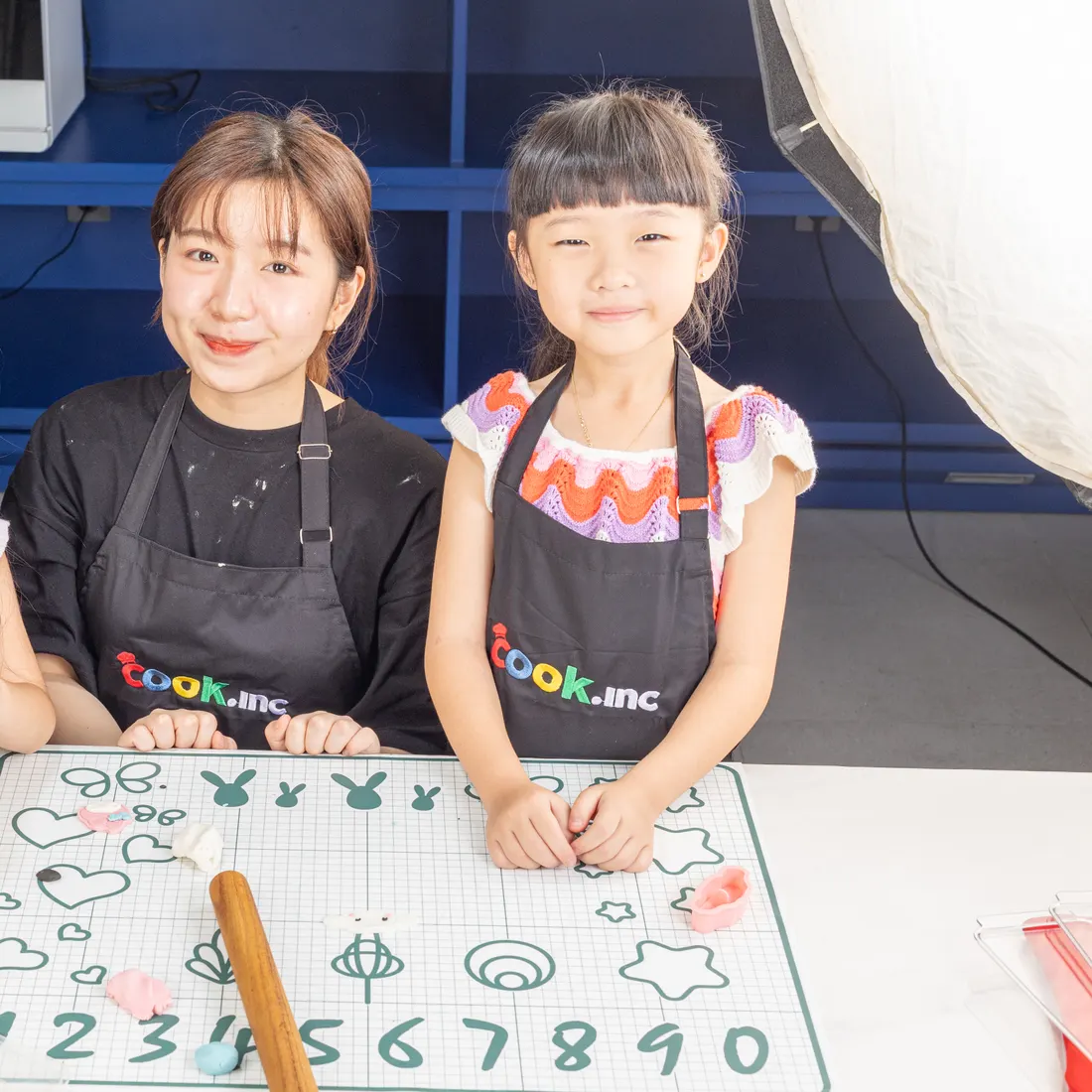 A chef and a little chef at the worktop during a class
