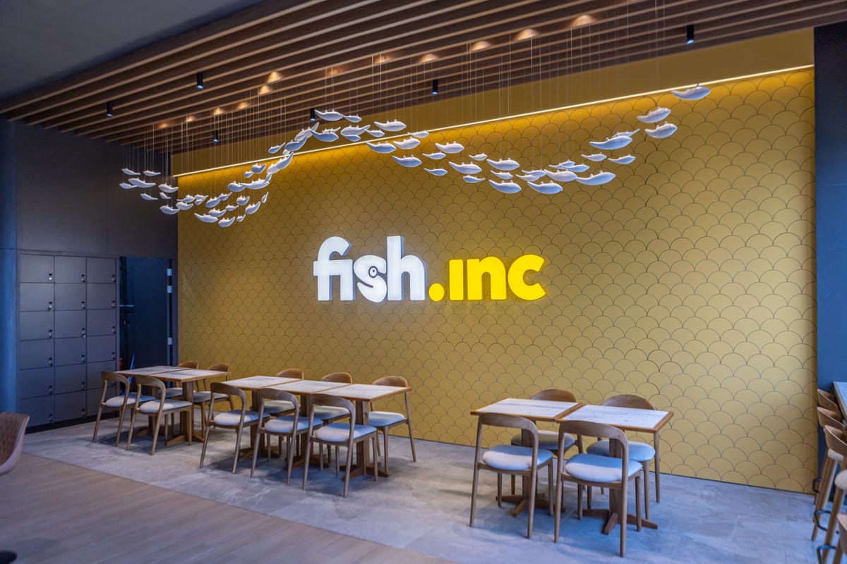 Café seating beside the fish.inc wall graphic