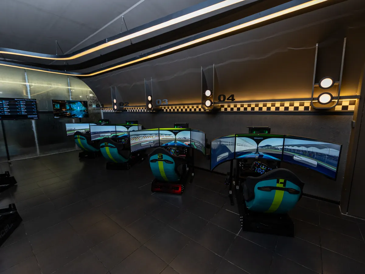 The Race.inc room seen wide, with four bays lined up under their numbered lamps