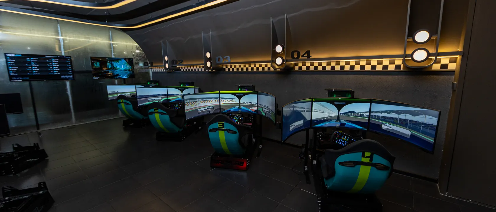 The full Race.inc room, six bays under the checkered band and the timing board